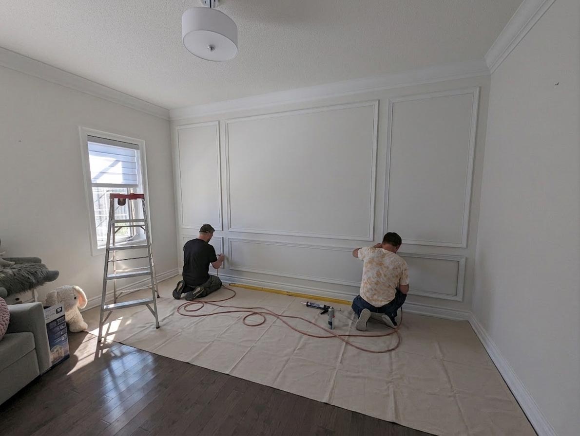 Drop-cloth floor protection during feature wall installation in luxury Toronto home