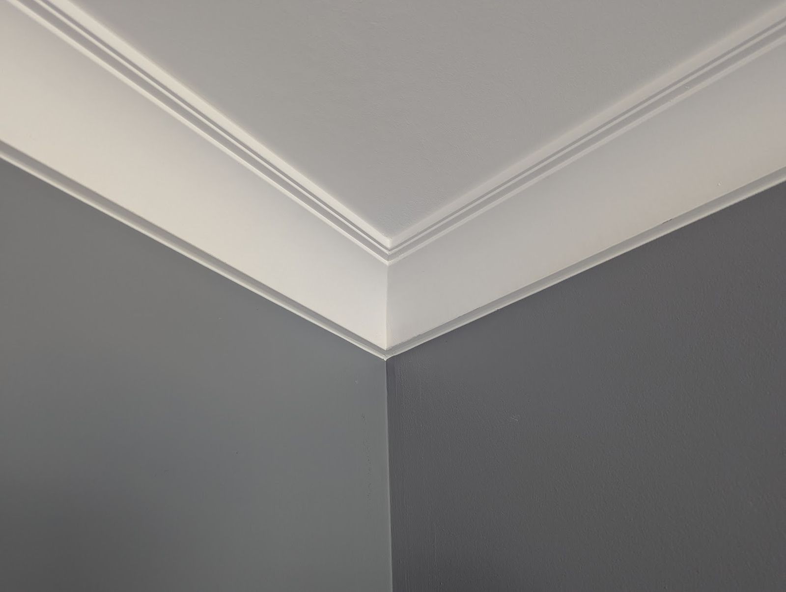Close-up of a crown moulding inside corner with caulked top and bottom edges