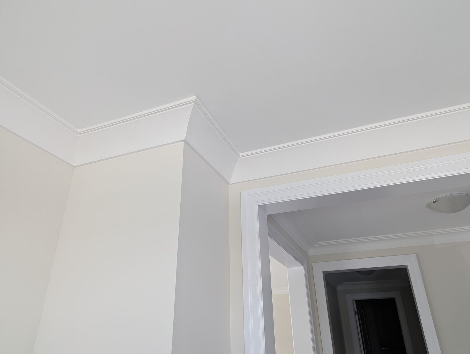 Crown moulding around a bulkhead, continuing through a doorway into the next rooms