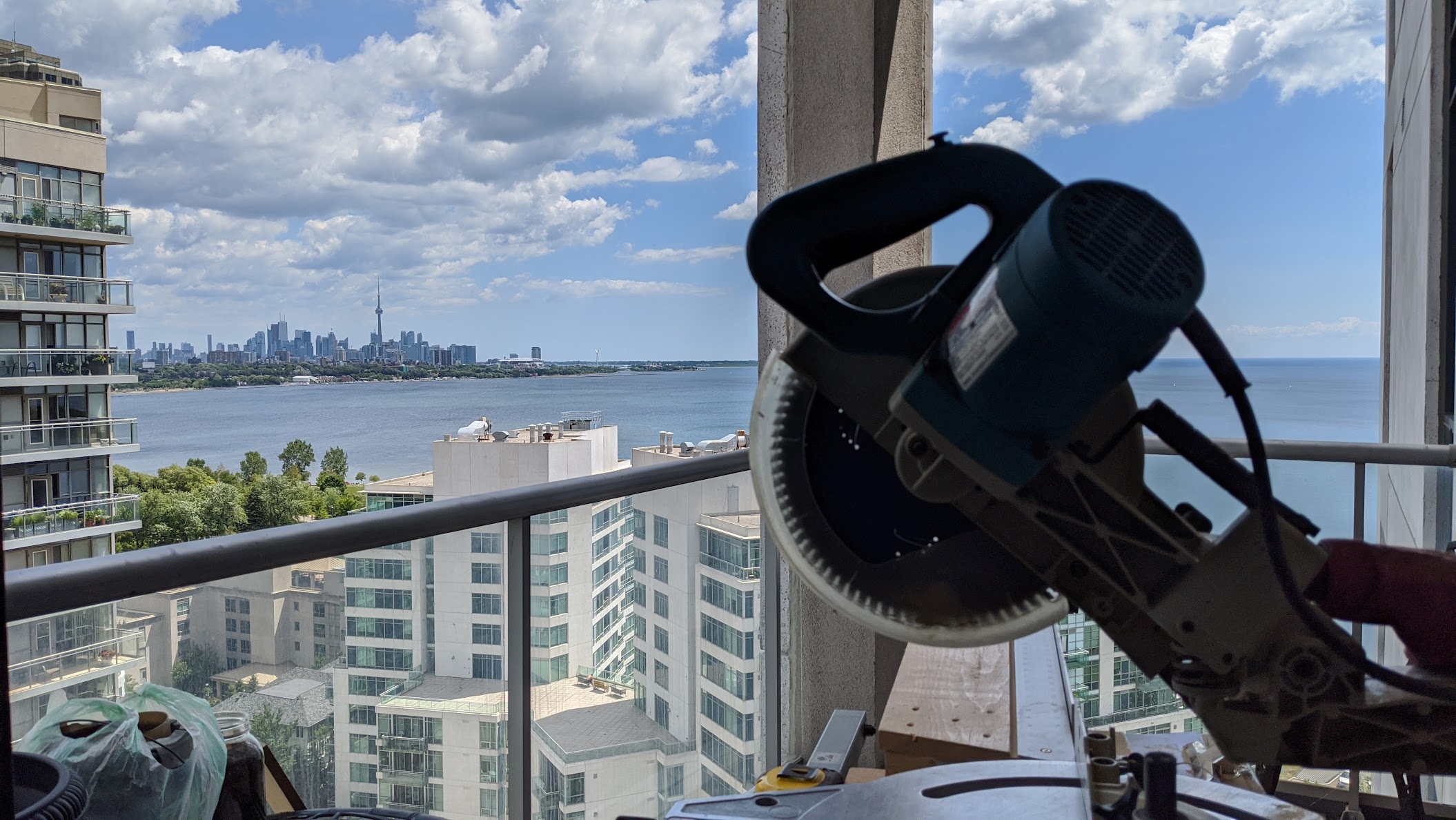 Mitre saw on a Toronto condo balcony overlooking the skyline during a crown moulding install