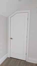 Custom interior door fitted to a sloped ceiling with angled casing by Expert Crown Moulding