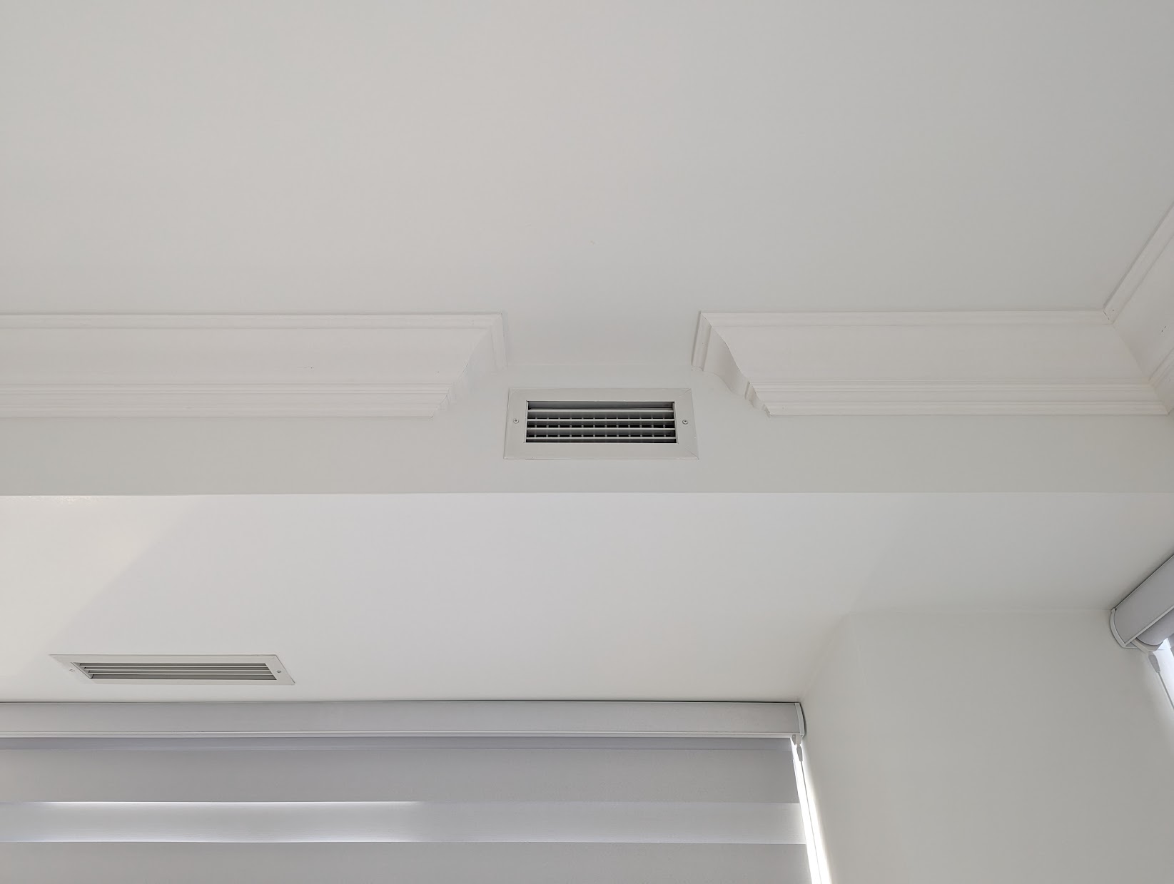 Crown moulding terminating with a clean 90-degree return around a ceiling vent