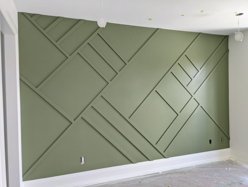 Green geometric feature wall with diagonal and horizontal moulding layout