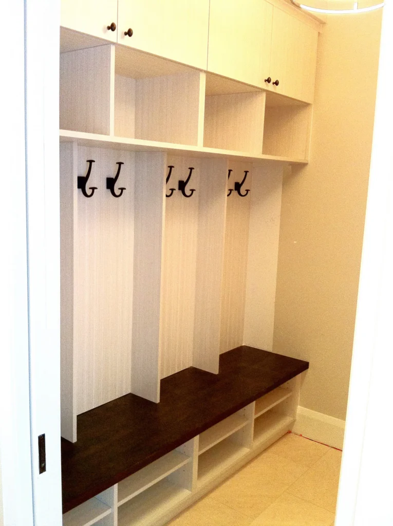 Custom mudroom and foyer bench with hooks and storage by Expert Crown Moulding