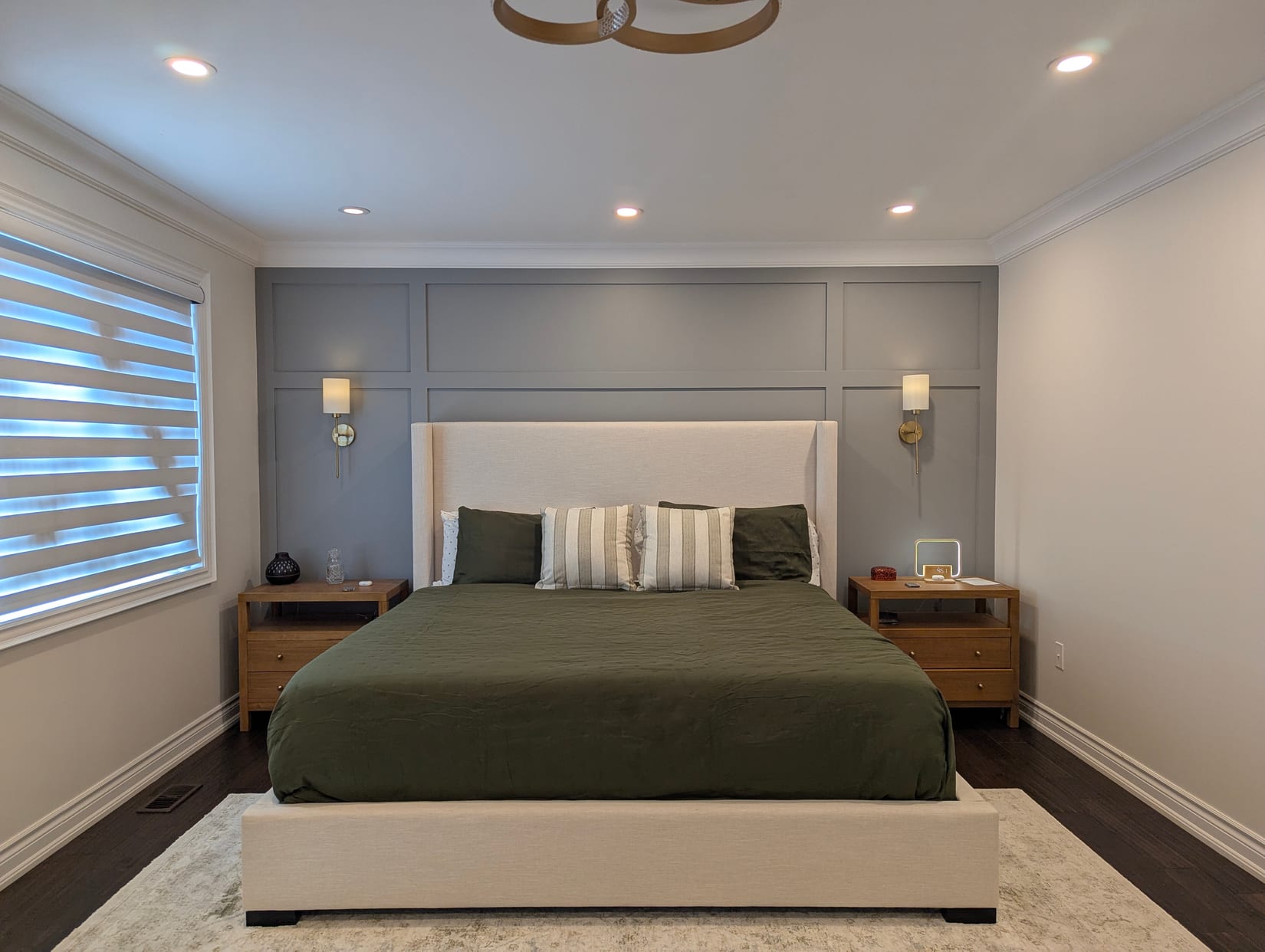 Panelled accent wall behind an upholstered bed in a Mississauga bedroom