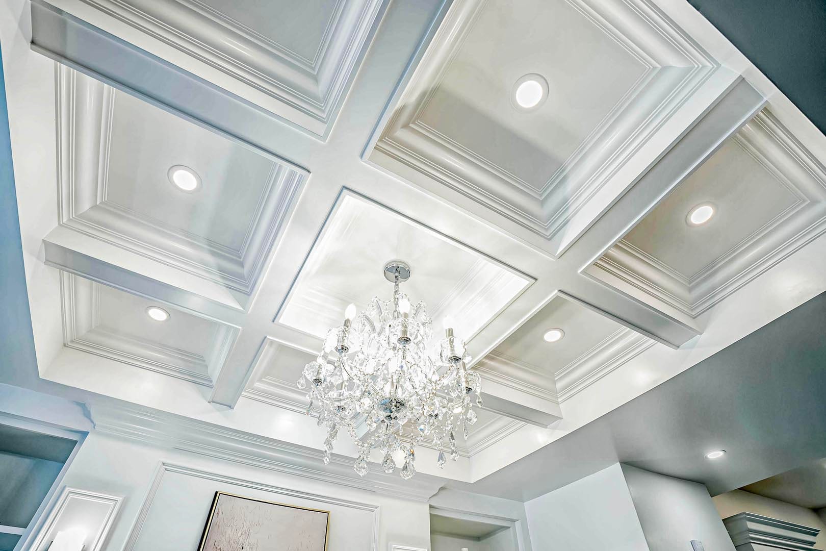 Deep coffered ceiling with recessed lights and a crystal chandelier in Mississauga