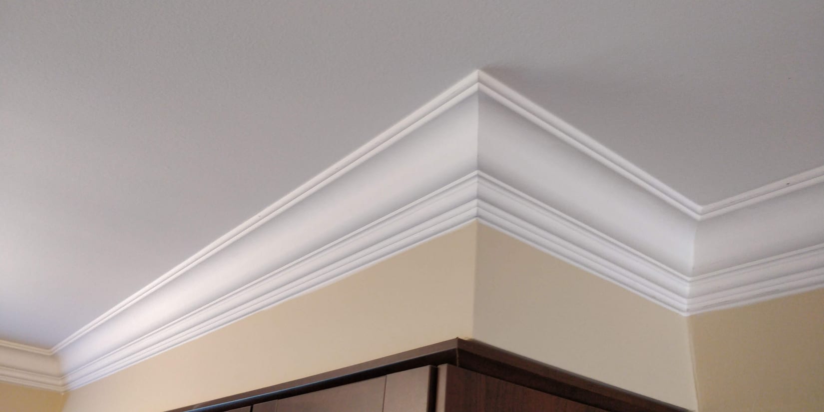 Five-inch Tuscany crown moulding at a condo ceiling corner, a profile we fit across Mississauga