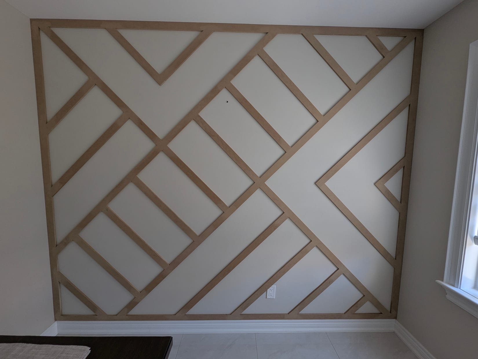Unpainted MDF geometric feature wall mid-installation in an Oakville bedroom