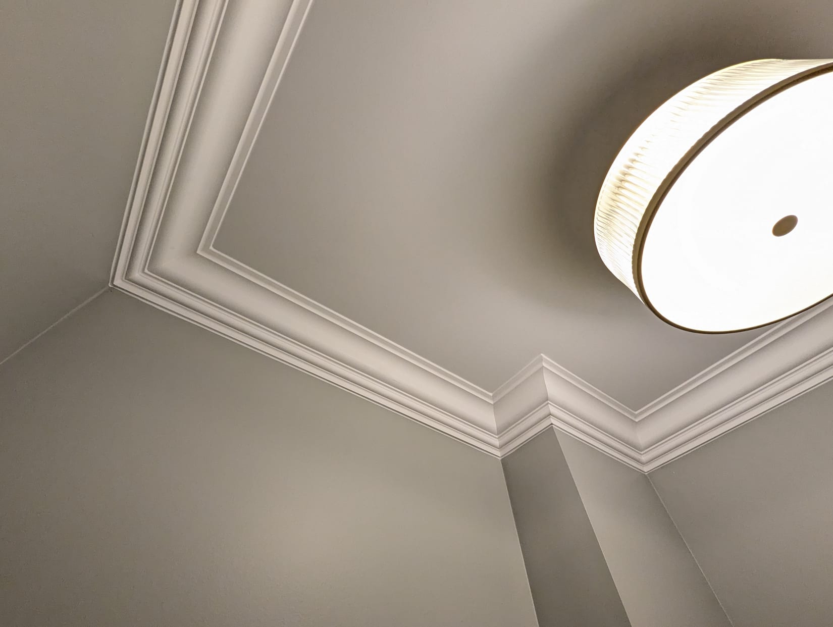 Multi-piece crown moulding running around an angled tray ceiling in Oakville