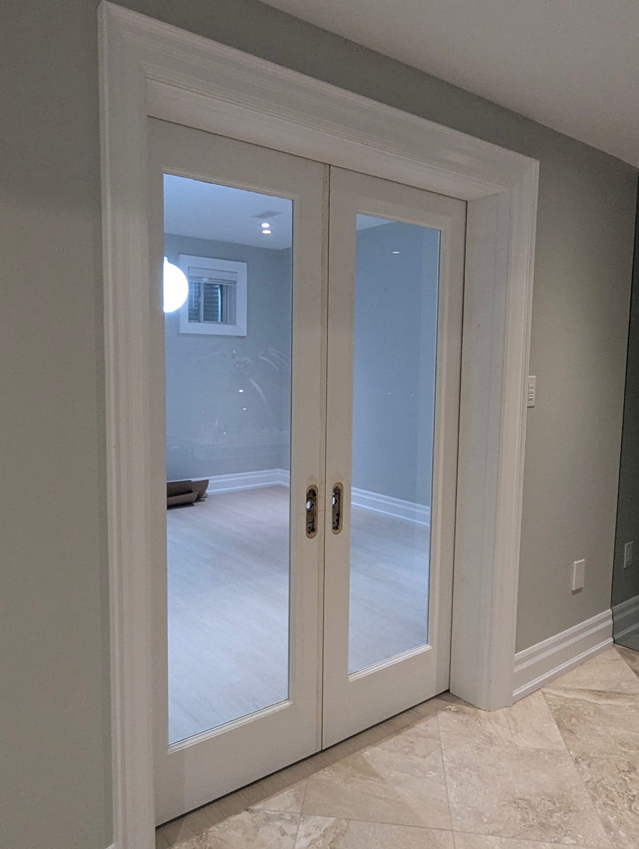 Double glass interior doors with casing and baseboard installed in an Oakville home