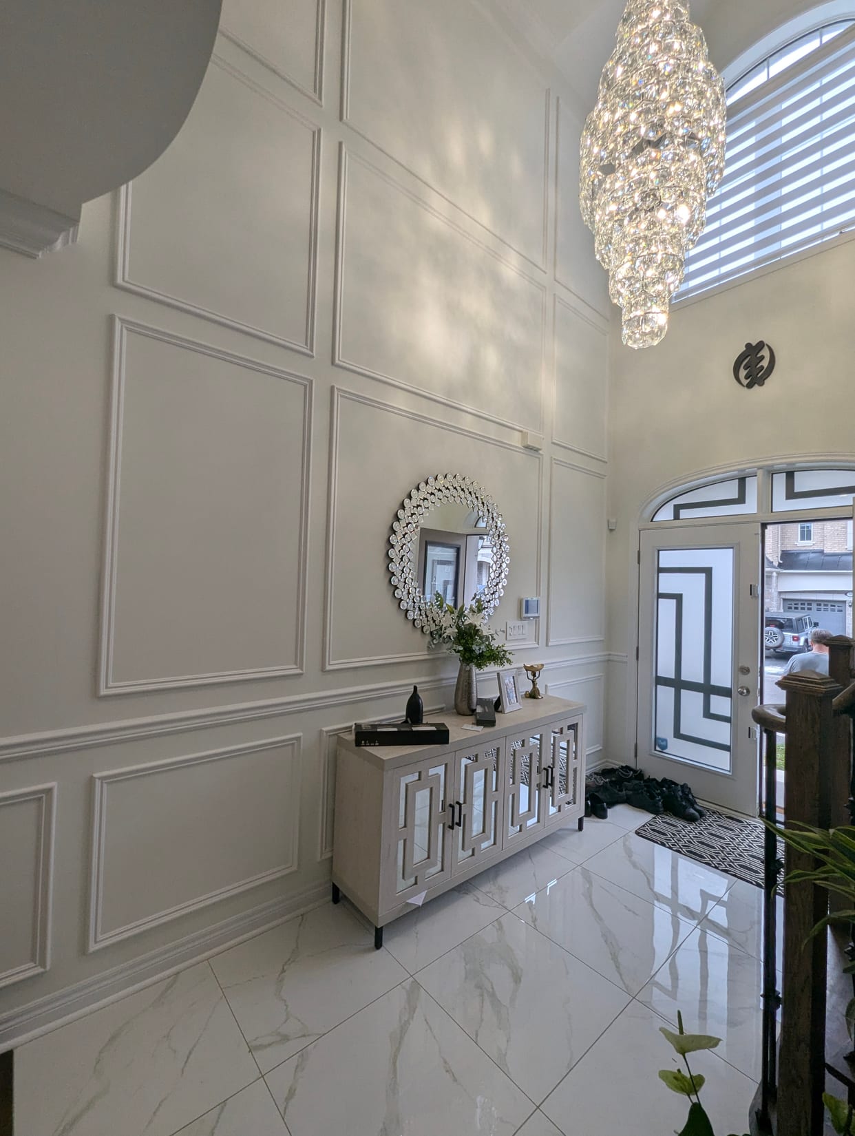 Full-height panel moulding in a two-storey Oakville foyer with marble tile floor