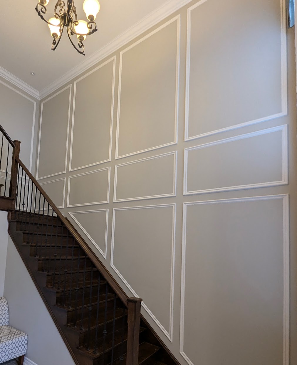 Full-height stair paneling running up the stairwell by Expert Crown Moulding
